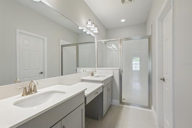 bathroom with a shower with shower door, tile patterned floors, and dual vanity