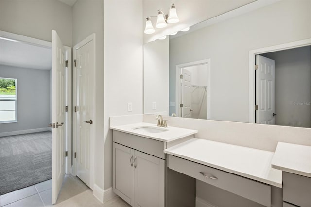 bathroom with a spacious closet, tile patterned flooring, vanity, and baseboards