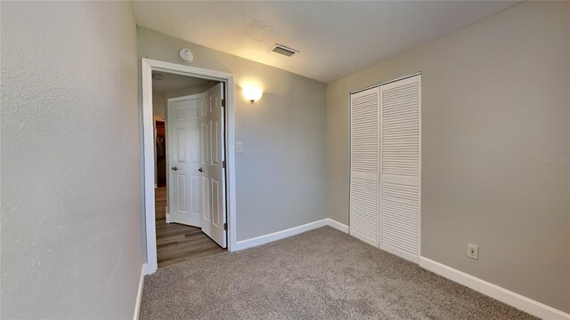 unfurnished bedroom featuring carpet floors, a closet, and baseboards