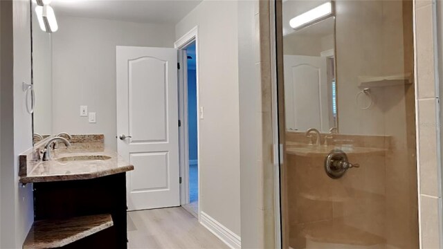 bathroom featuring a stall shower, vanity, and wood finished floors