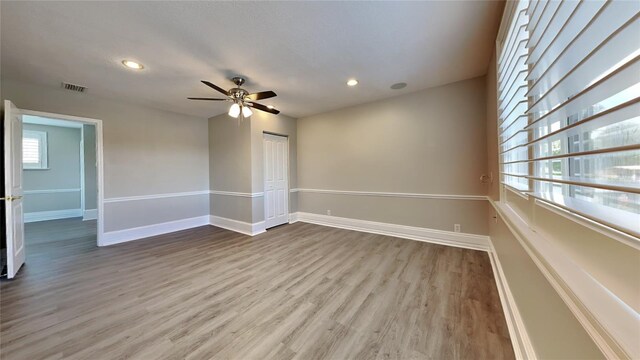 spare room with baseboards, visible vents, wood finished floors, and recessed lighting