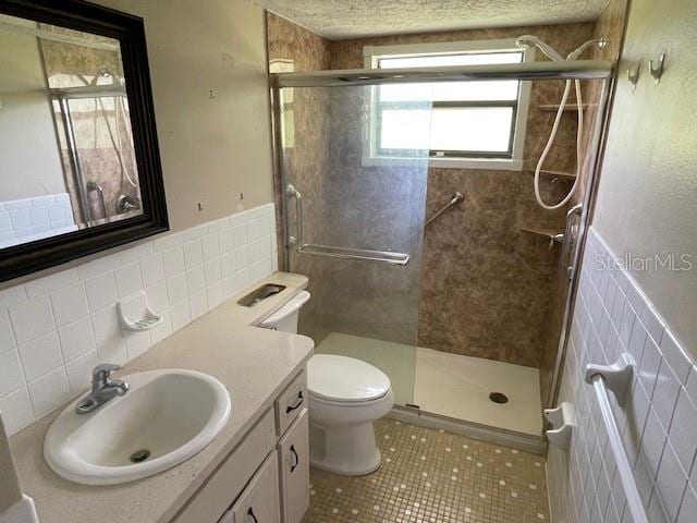 bathroom featuring toilet, walk in shower, vanity, backsplash, and tile walls