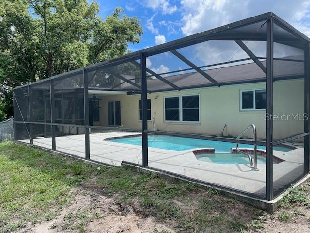 view of pool featuring glass enclosure and a patio area