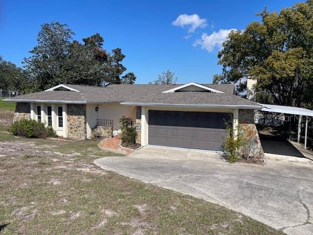 ranch-style house with concrete driveway, an attached garage, stone siding, and stucco siding