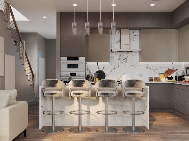 kitchen with light wood finished floors, modern cabinets, and a breakfast bar area