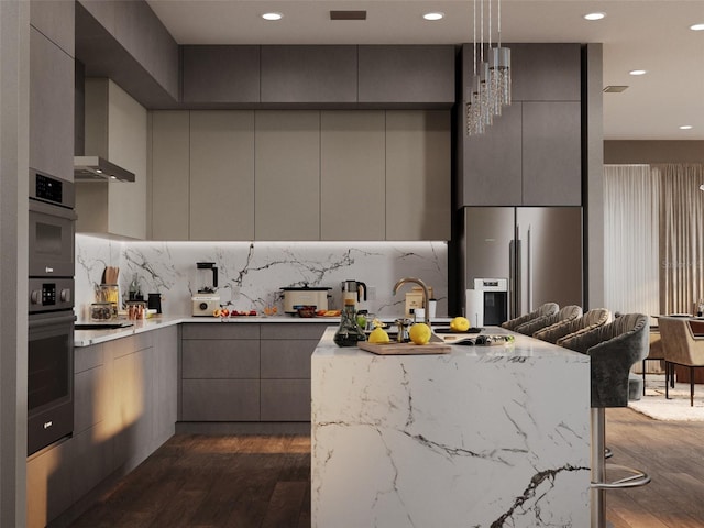 kitchen with modern cabinets, a kitchen breakfast bar, stainless steel appliances, gray cabinetry, and pendant lighting