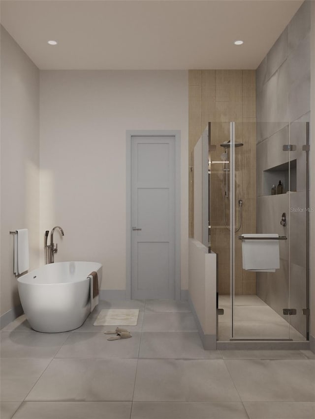 bathroom featuring tile patterned flooring, a freestanding bath, a shower stall, and baseboards