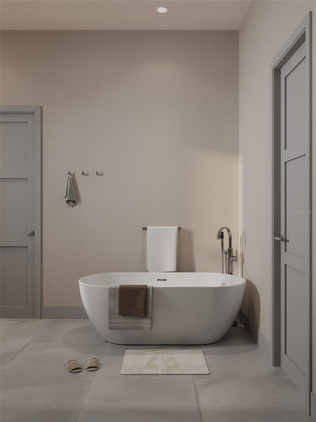 bathroom with tile patterned flooring, a freestanding bath, baseboards, and recessed lighting