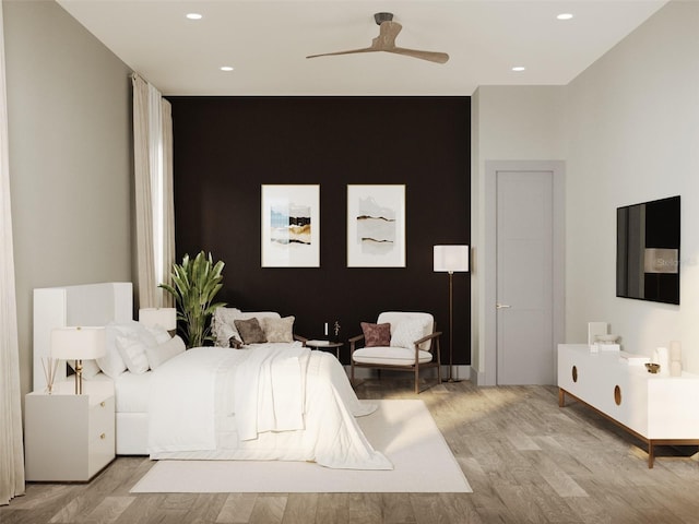 bedroom featuring an accent wall, light wood-type flooring, a ceiling fan, and recessed lighting