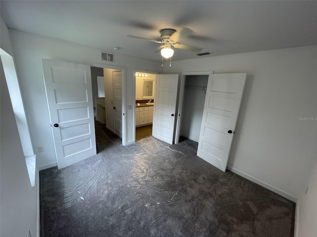 unfurnished bedroom featuring a closet, ensuite bath, and ceiling fan