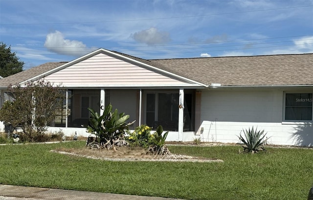 rear view of property with a sunroom and a yard