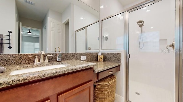 bathroom featuring ceiling fan, vanity, and a shower with door