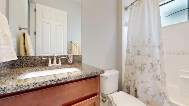 full bathroom with toilet, vanity, and shower / bath combination with curtain