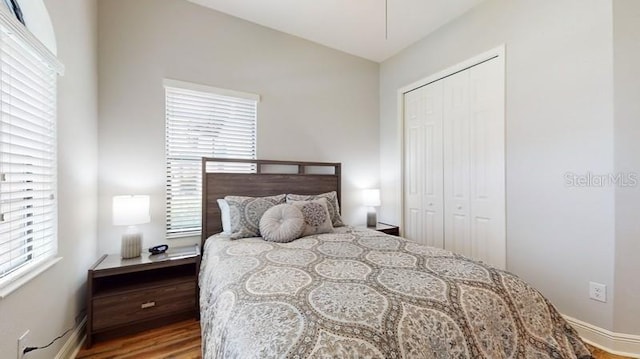 bedroom featuring hardwood / wood-style floors, a closet, and vaulted ceiling