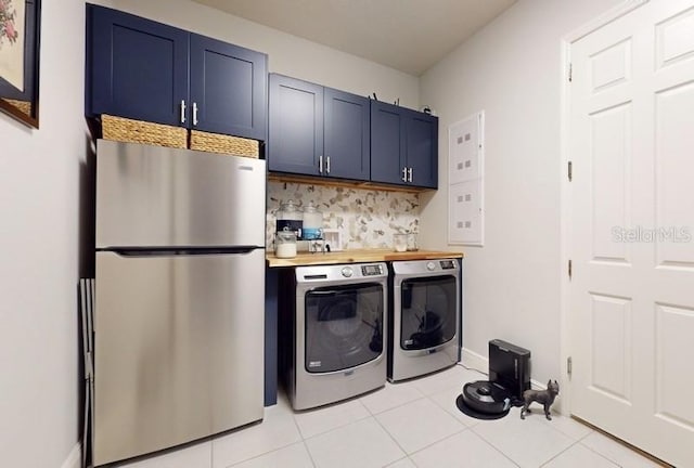 laundry area featuring cabinets, light tile patterned flooring, and separate washer and dryer