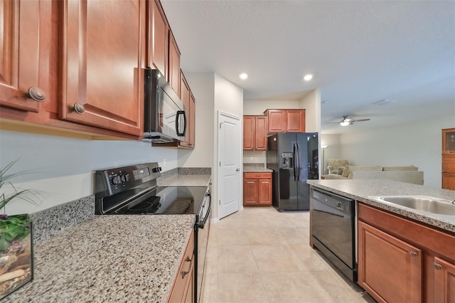 kitchen featuring light stone counters, sink, black appliances, and ceiling fan