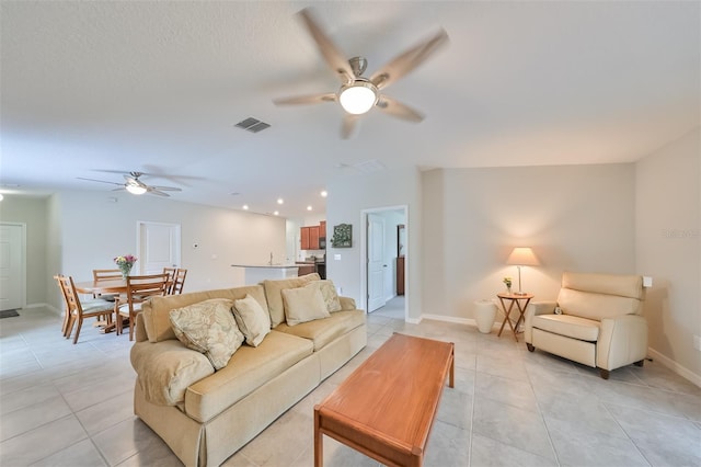 tiled living room featuring ceiling fan