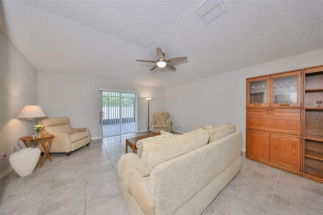 tiled living room featuring ceiling fan and a textured ceiling