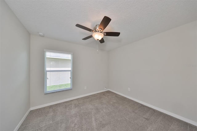 carpeted empty room featuring ceiling fan and a textured ceiling