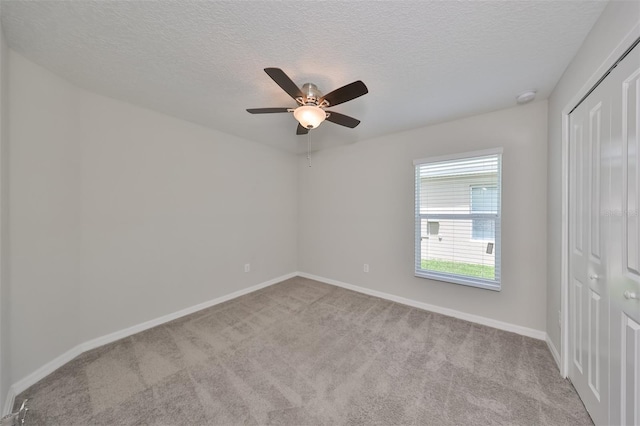 interior space featuring ceiling fan, light carpet, and a textured ceiling