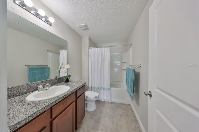 full bathroom featuring vanity, shower / bath combination with curtain, a textured ceiling, tile patterned floors, and toilet