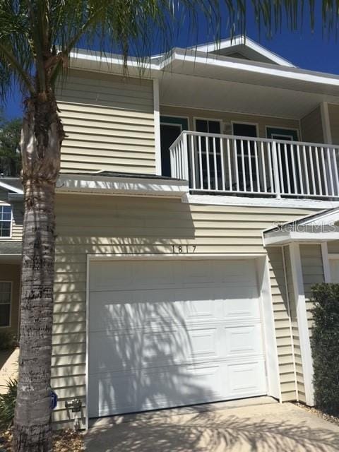 view of property exterior featuring a garage, driveway, and a balcony