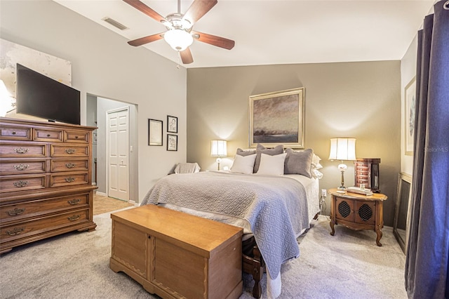 bedroom featuring ceiling fan, a closet, light colored carpet, and vaulted ceiling