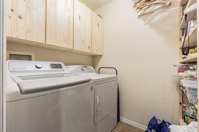 washroom featuring cabinets, separate washer and dryer, and light tile patterned floors