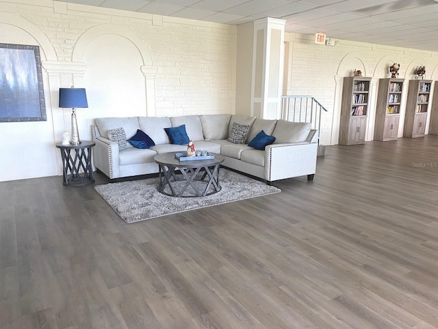 living room featuring dark hardwood / wood-style flooring and brick wall