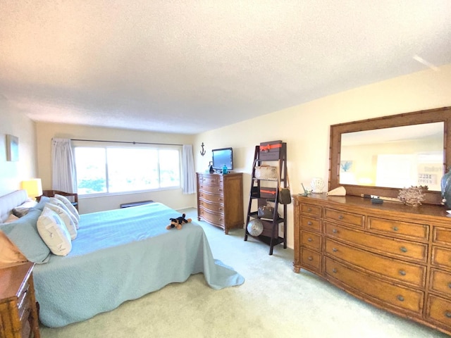 bedroom featuring light carpet and a textured ceiling