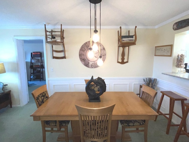 carpeted dining space featuring ornamental molding