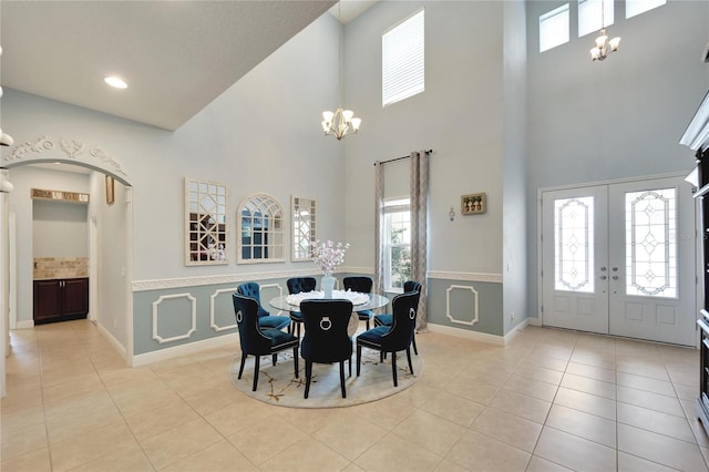 19300 Lonesome Pine Dr, Land O Lakes, FL 34638 - dining area with baseboards, arched walkways, french doors, a chandelier, and light tile patterned flooring