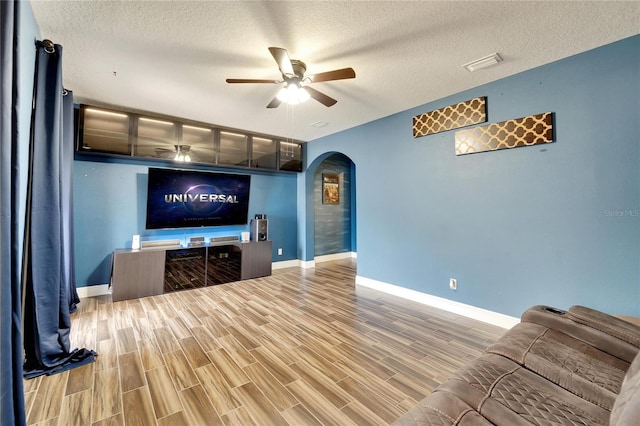 19300 Lonesome Pine Dr, Land O Lakes, FL 34638 - living area featuring visible vents, arched walkways, a ceiling fan, wood finished floors, and a textured ceiling