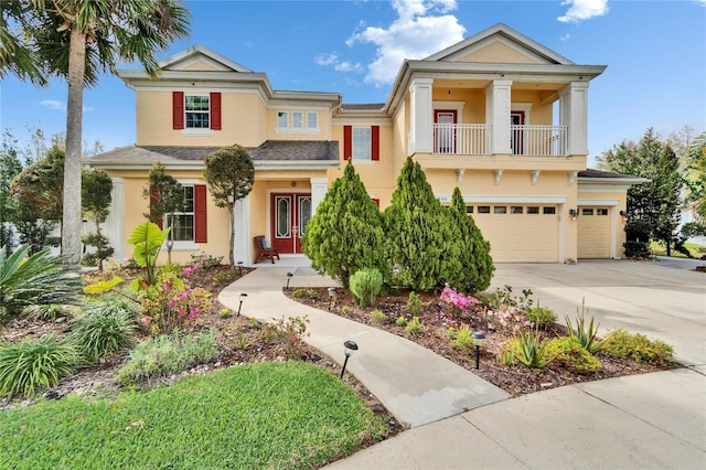 19300 Lonesome Pine Dr, Land O Lakes, FL 34638 - view of front facade featuring a garage, driveway, a balcony, and stucco siding