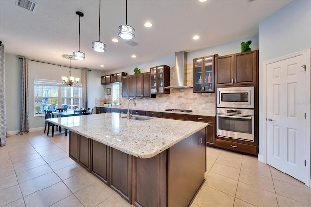 19300 Lonesome Pine Dr, Land O Lakes, FL 34638 - kitchen featuring stainless steel appliances, visible vents, light tile patterned flooring, a sink, and wall chimney range hood