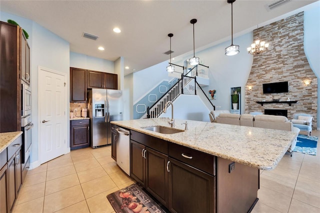 19300 Lonesome Pine Dr, Land O Lakes, FL 34638 - kitchen with appliances with stainless steel finishes, visible vents, a sink, and a fireplace