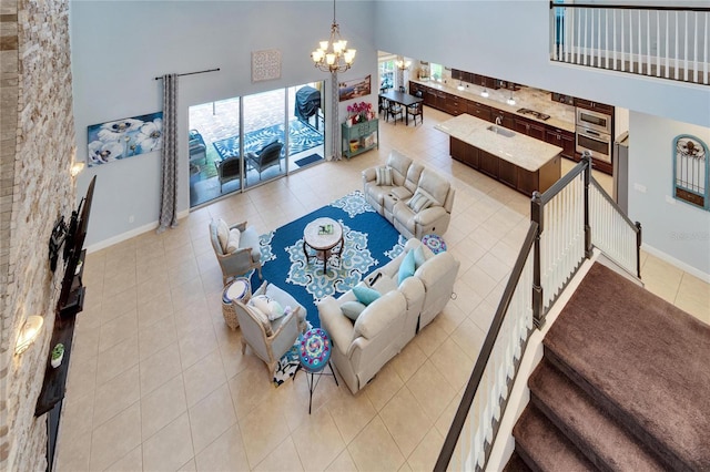19300 Lonesome Pine Dr, Land O Lakes, FL 34638 - living room with baseboards, a high ceiling, light tile patterned floors, and an inviting chandelier
