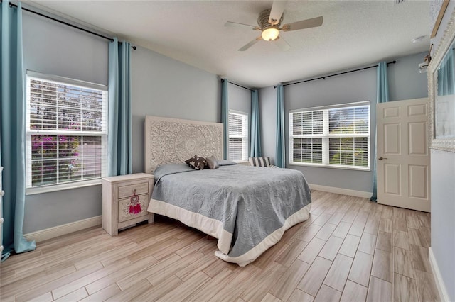 19300 Lonesome Pine Dr, Land O Lakes, FL 34638 - bedroom with light wood-type flooring, multiple windows, and a textured ceiling