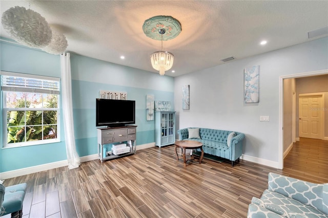 19300 Lonesome Pine Dr, Land O Lakes, FL 34638 - living room featuring an inviting chandelier, baseboards, visible vents, and wood finished floors