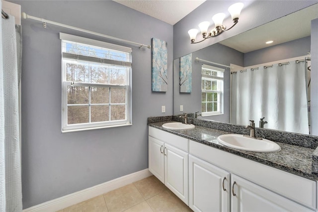 19300 Lonesome Pine Dr, Land O Lakes, FL 34638 - bathroom featuring double vanity, tile patterned flooring, baseboards, and a sink