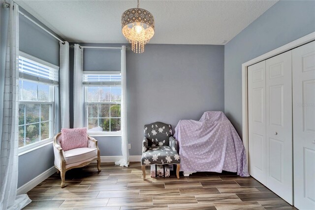 19300 Lonesome Pine Dr, Land O Lakes, FL 34638 - living area with baseboards, wood finish floors, a textured ceiling, and a notable chandelier