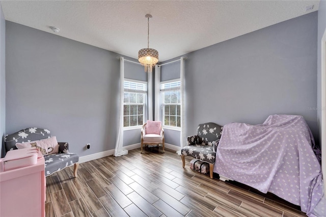 19300 Lonesome Pine Dr, Land O Lakes, FL 34638 - living area featuring wood finish floors, a notable chandelier, a textured ceiling, and baseboards