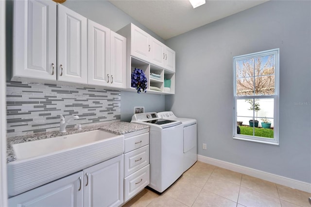 19300 Lonesome Pine Dr, Land O Lakes, FL 34638 - washroom with light tile patterned floors, cabinet space, washing machine and dryer, a sink, and baseboards