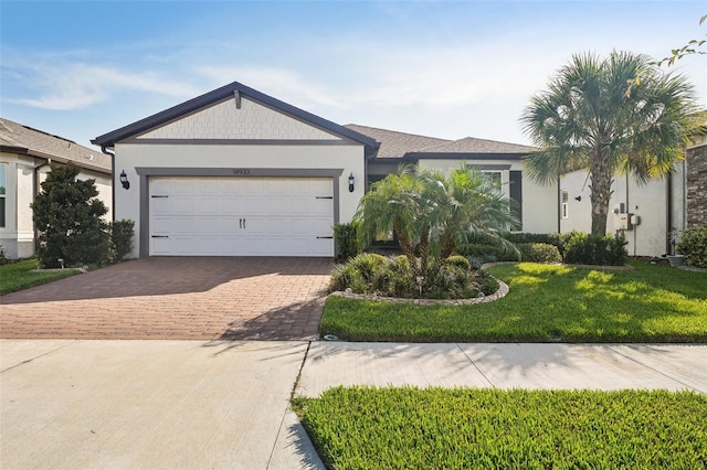 ranch-style home featuring a garage and a front lawn