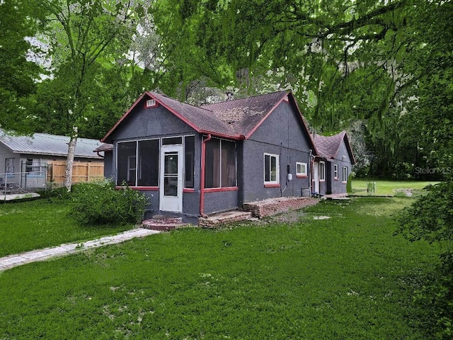 view of front facade featuring a sunroom and a front yard