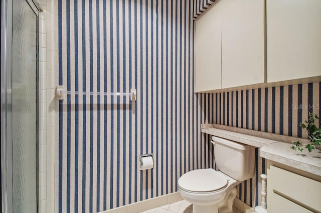 bathroom featuring a shower with shower door, tile patterned floors, and toilet