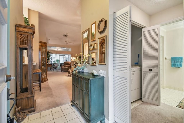 hallway featuring washer / dryer and light colored carpet