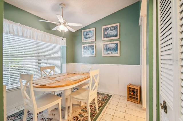 tiled dining area featuring ceiling fan and vaulted ceiling