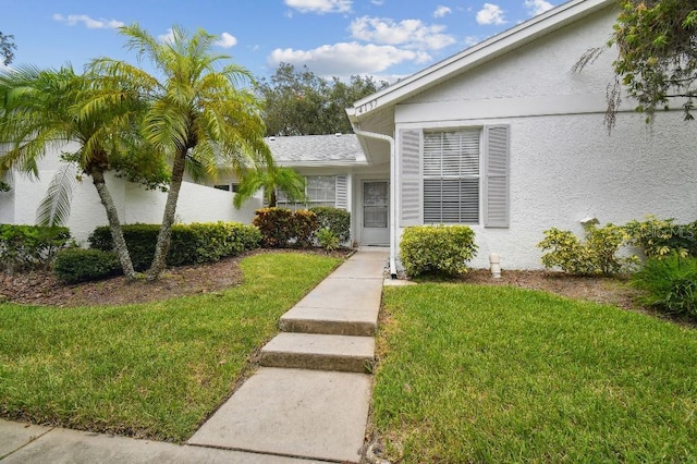 view of exterior entry with a yard