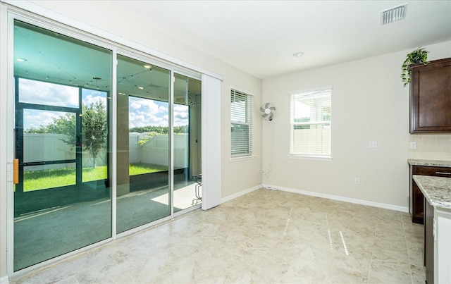 interior space featuring light tile patterned flooring and a healthy amount of sunlight